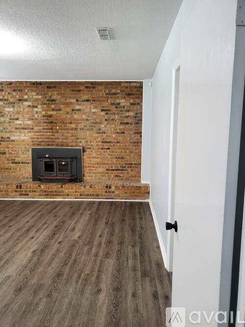 A room with a brick wall and a wood floor.
