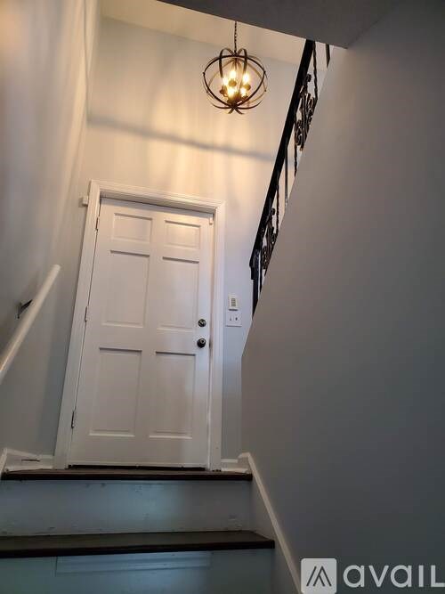 A white door is at the bottom of a staircase.