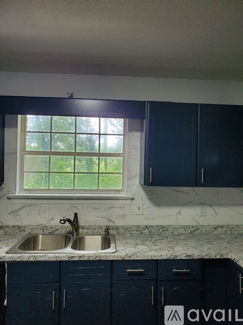 A kitchen with a marble countertop and a window.