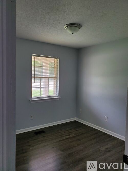 A room with a window and wooden floors.