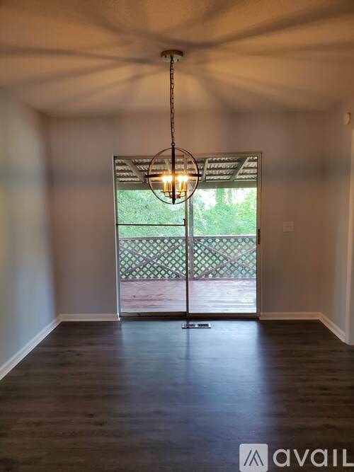 A room with a wooden floor and a hanging light fixture.