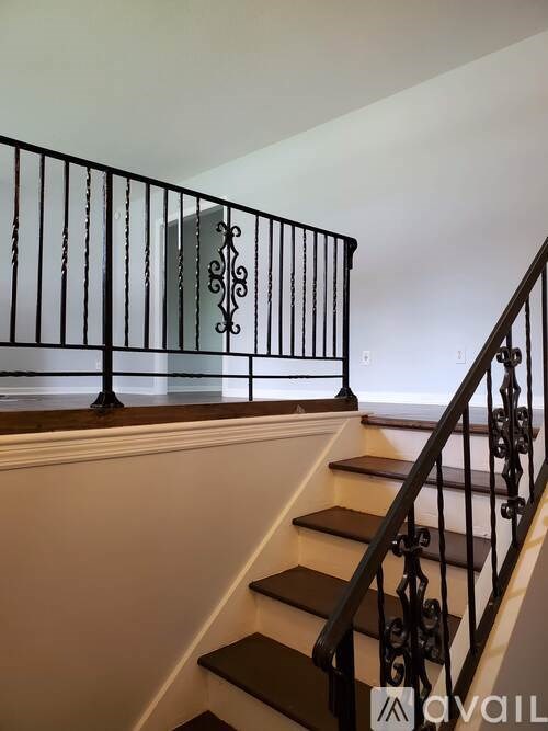 A staircase with a black railing and wooden steps.