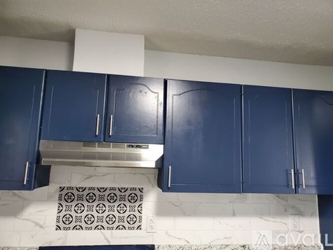 A kitchen with blue cabinets and a white countertop.