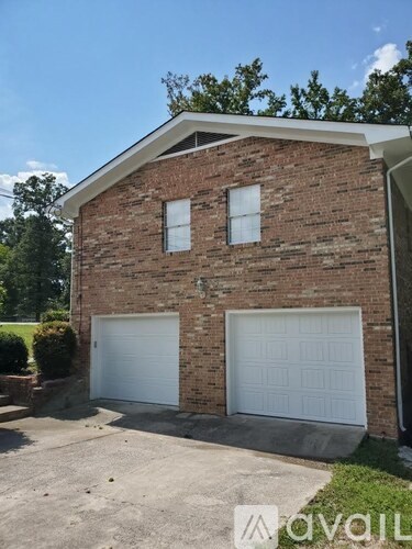 A two-car garage is attached to a brick house.
