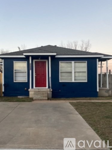 A blue house with a red door and a red garage door.