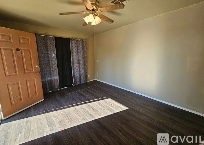 A room with a ceiling fan and a rug on the floor.