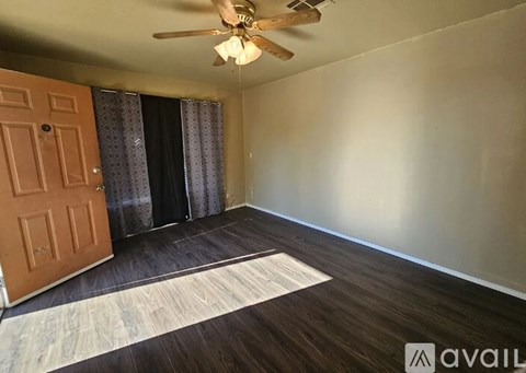 A room with a ceiling fan and a rug on the floor.