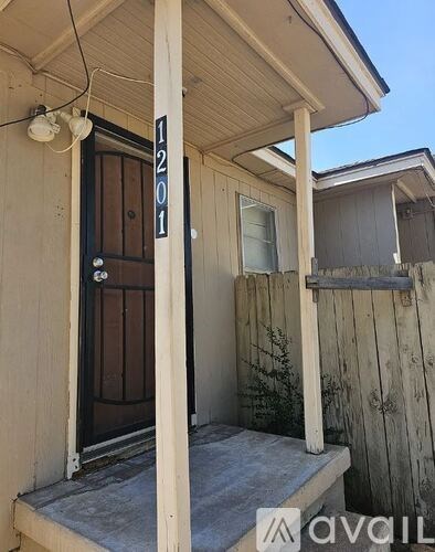 A wooden house with a brown door and a window.