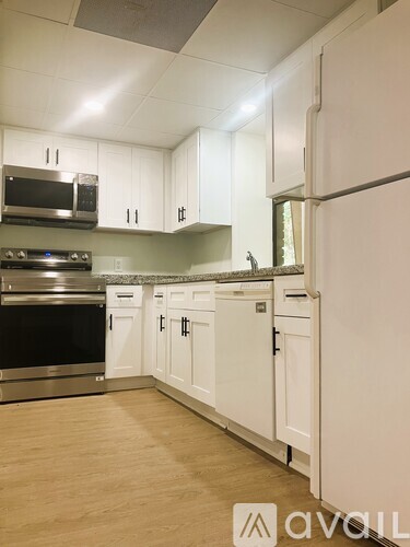 A kitchen with white cabinets and a stainless steel oven.