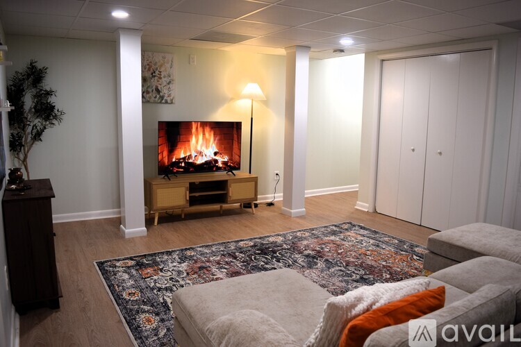 A living room with a fireplace and a rug on the floor.