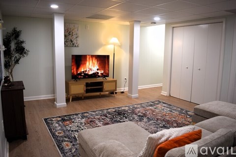 A living room with a fireplace and a rug on the floor.