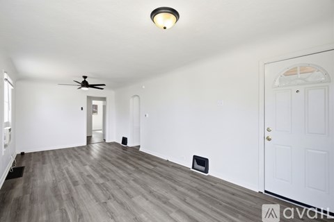 A long hallway with a light on the ceiling and a sign that says "available".
