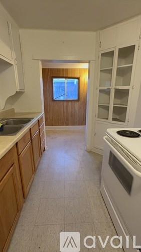 A kitchen with white appliances and wooden cabinets.