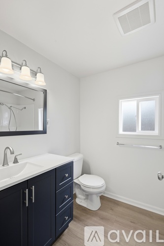 A bathroom with a toilet, sink, and mirror.
