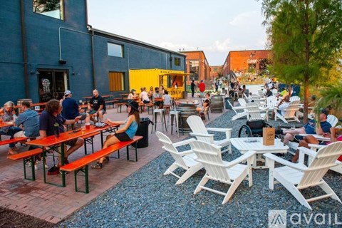 A group of people are sitting at tables outside a building.