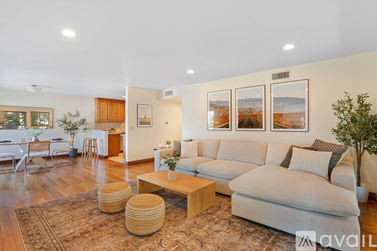 A living room with a white couch and a rug.