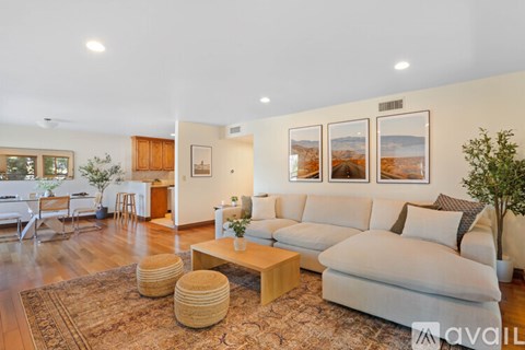 A living room with a white couch and a rug.