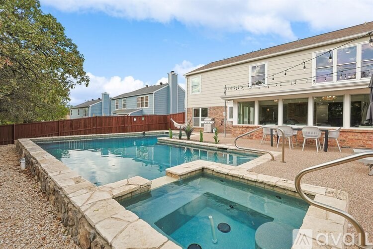 A backyard with a small pool and patio furniture.