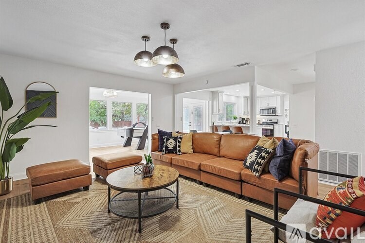 A living room with a brown leather couch and a glass coffee table.