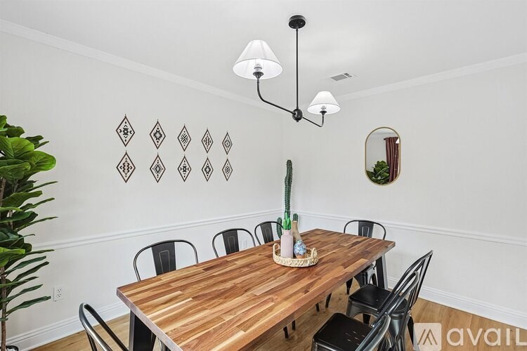 A wooden dining table with chairs and a cactus plant on top.