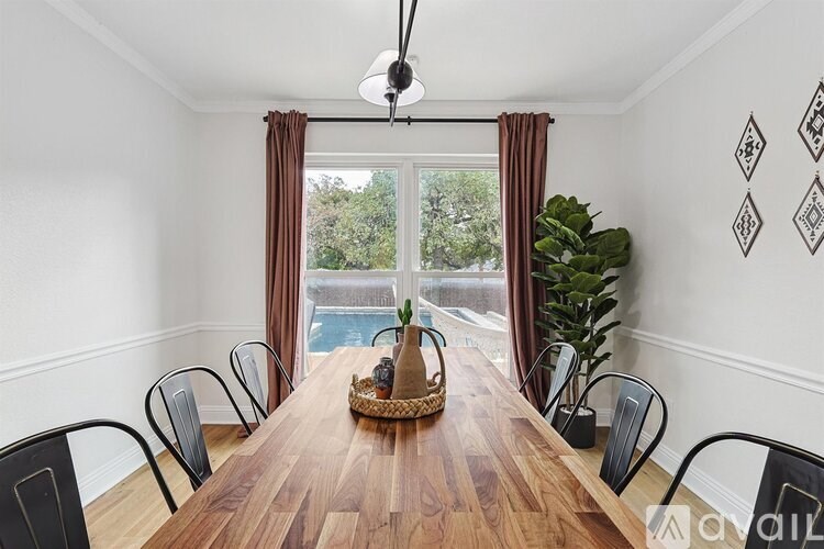 A dining room with a wooden table and chairs.