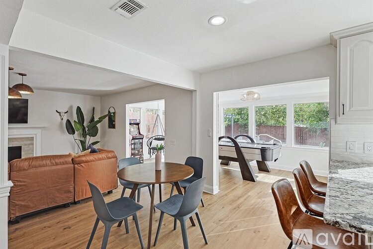 A dining room with a round table and chairs.