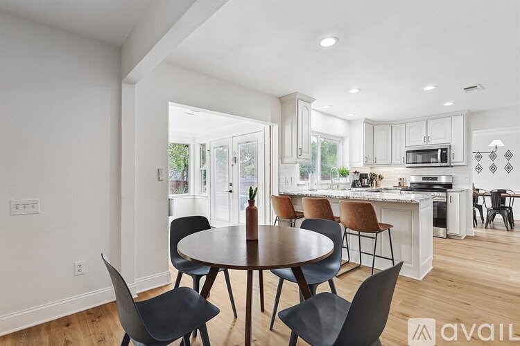 A modern kitchen with a dining table and chairs.