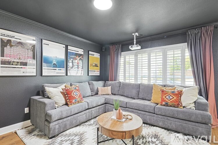 A grey couch with a coffee table in front of it.