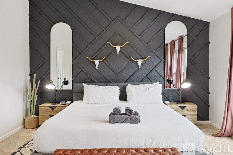 A bedroom with a white bed and a black wallpaper.