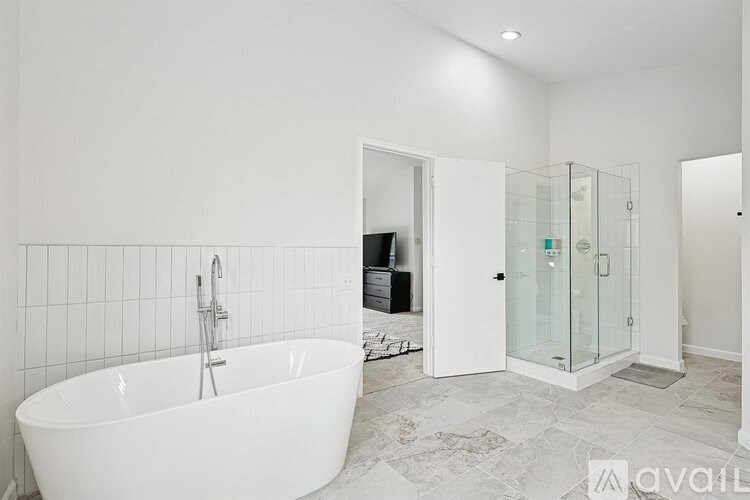 A white bathroom with a tub and a walk in shower.