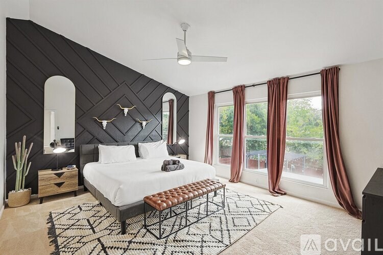 A bedroom with a large bed and a ceiling fan.