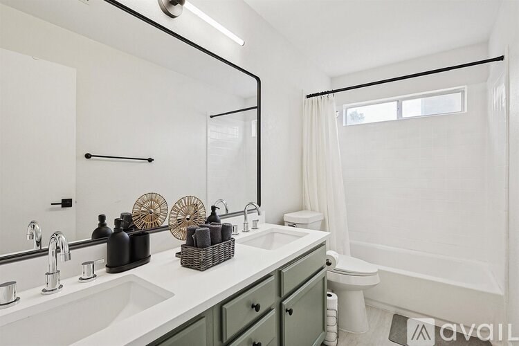 A bathroom with a white sink and a mirror above it.