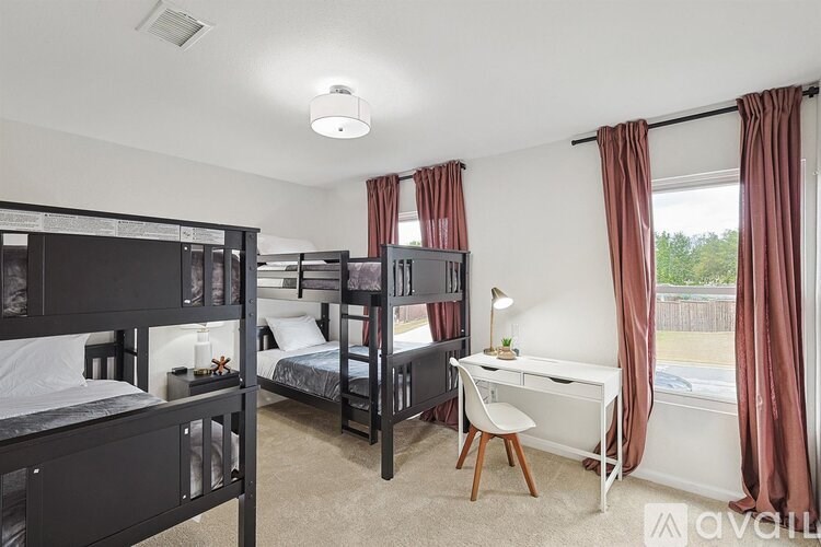 A bedroom with bunk beds and a desk.