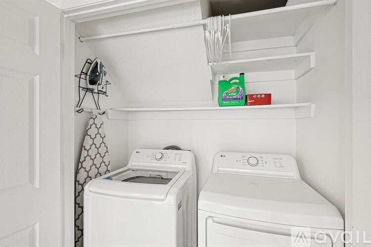 A small laundry room with a washer and dryer.