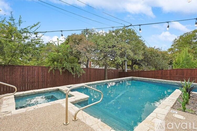 A small pool with a metal railing and a stone border.