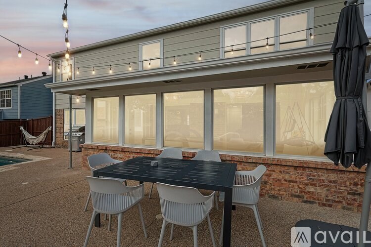 A patio with a table and chairs is set up outside a house.