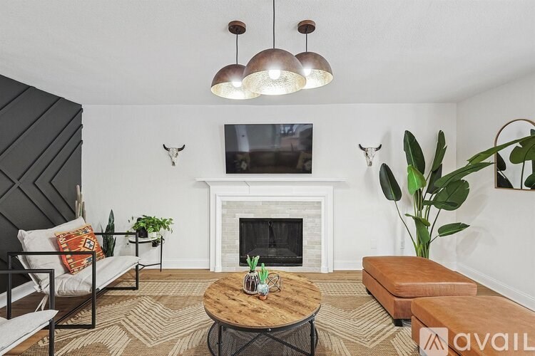 A living room with a fireplace and a TV mounted above it.