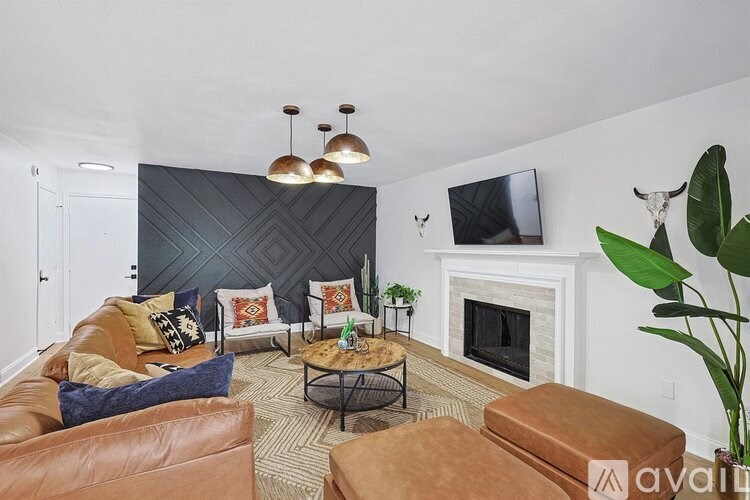 A living room with a fireplace and a TV mounted on the wall.