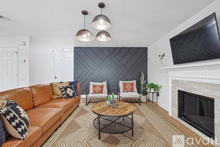 A living room with a brown leather couch, a coffee table, and a fireplace.