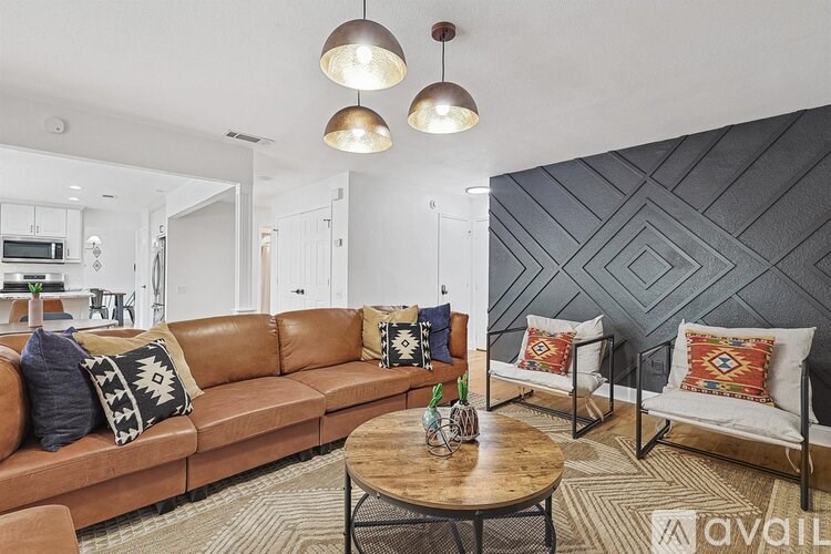 A living room with a brown leather couch and a wooden coffee table.