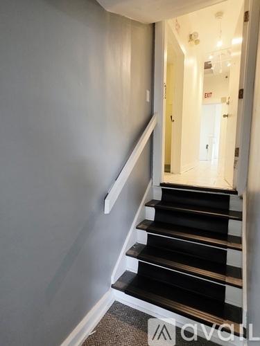 A staircase with black steps and white railings.