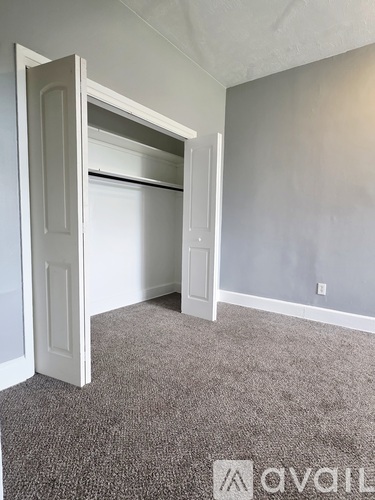 A room with a window and a carpeted floor.