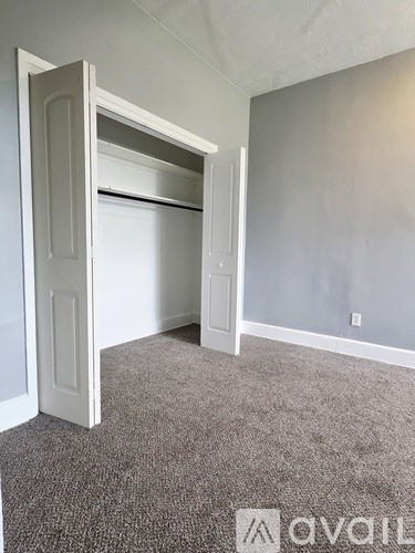 A room with a window and a carpeted floor.