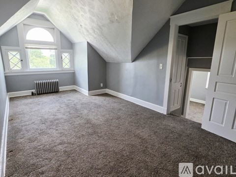 A bathroom with a walk in shower and a window.