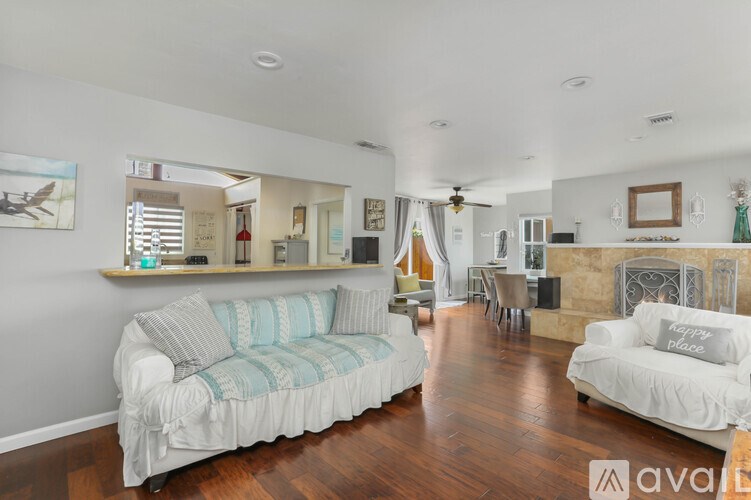 A living room with a white couch and wooden floors.