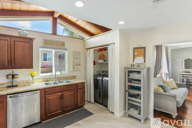 A kitchen with a refrigerator, sink, and a dishwasher.