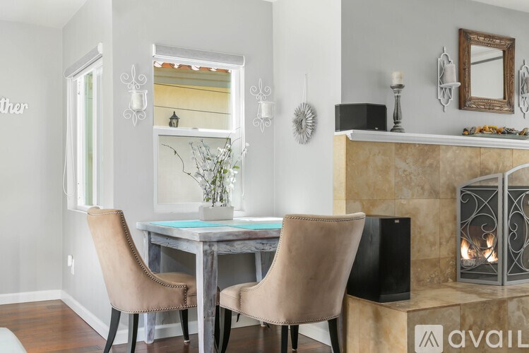 A dining room with a table, chairs and a fireplace.