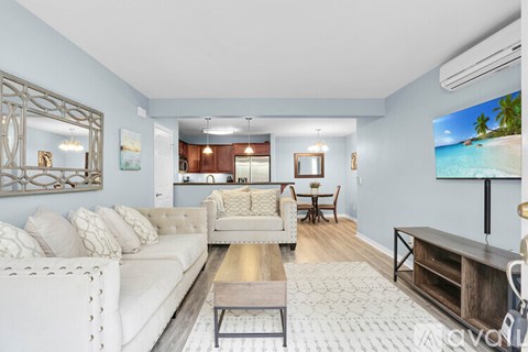 A living room with a white sofa and a wooden coffee table.