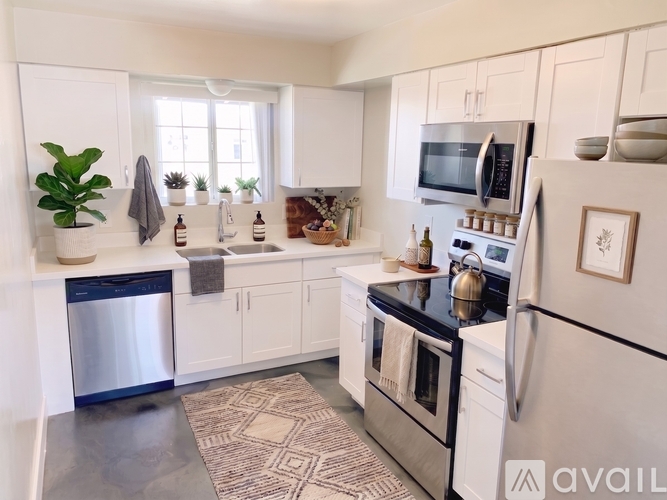A kitchen with white appliances and cabinets.