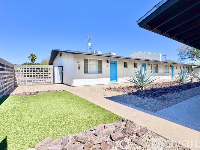 A house with a blue door and a pool in the backyard.
